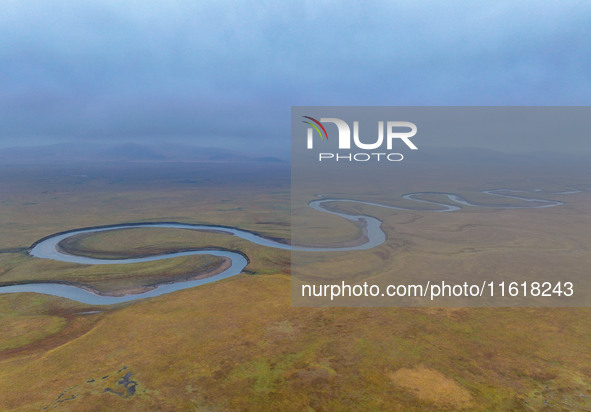 An aerial photo taken in Hulunbuir, China, on September 28, 2024, shows the winding Mogoler River passing through the grassland during autum...