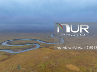 An aerial photo taken in Hulunbuir, China, on September 28, 2024, shows the winding Mogoler River passing through the grassland during autum...