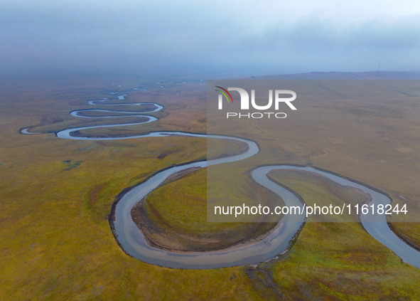 An aerial photo taken in Hulunbuir, China, on September 28, 2024, shows the winding Mogoler River passing through the grassland during autum...