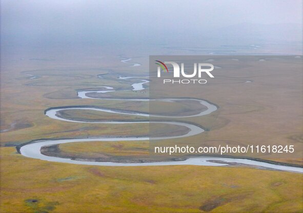 An aerial photo taken in Hulunbuir, China, on September 28, 2024, shows the winding Mogoler River passing through the grassland during autum...