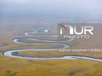 An aerial photo taken in Hulunbuir, China, on September 28, 2024, shows the winding Mogoler River passing through the grassland during autum...