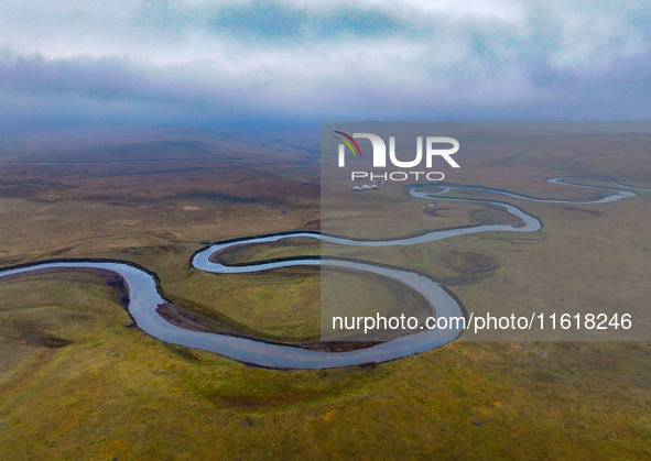 An aerial photo taken in Hulunbuir, China, on September 28, 2024, shows the winding Mogoler River passing through the grassland during autum...