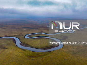 An aerial photo taken in Hulunbuir, China, on September 28, 2024, shows the winding Mogoler River passing through the grassland during autum...