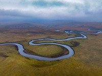 An aerial photo taken in Hulunbuir, China, on September 28, 2024, shows the winding Mogoler River passing through the grassland during autum...