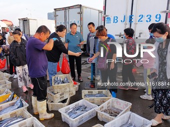 Citizens buy seafood at Jimiya Fishing Port in the West Coast New Area of Qingdao, Shandong province, China, on September 28, 2024. (