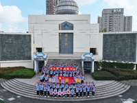 Primary school students pose for a photo with the national flag to celebrate the 75th anniversary of the founding of China in Taicang, Jiang...