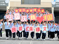 Primary school students pose for a photo with the national flag to celebrate the 75th anniversary of the founding of China in Taicang, Jiang...