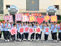 Primary school students pose for a photo with the national flag to celebrate the 75th anniversary of the founding of China in Taicang, Jiang...