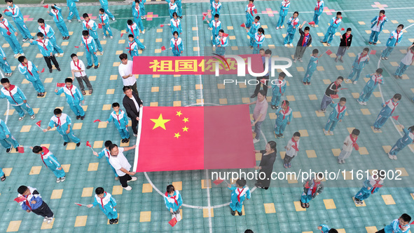 A prosecutor explains national flag knowledge to children at Qianhe Primary School in Situi Town, Guanyun County, Lianyungang City, Jiangsu...