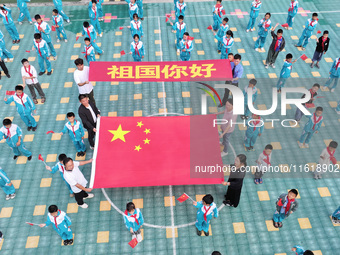 A prosecutor explains national flag knowledge to children at Qianhe Primary School in Situi Town, Guanyun County, Lianyungang City, Jiangsu...