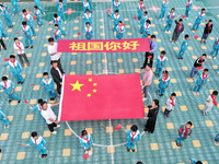 A prosecutor explains national flag knowledge to children at Qianhe Primary School in Situi Town, Guanyun County, Lianyungang City, Jiangsu...