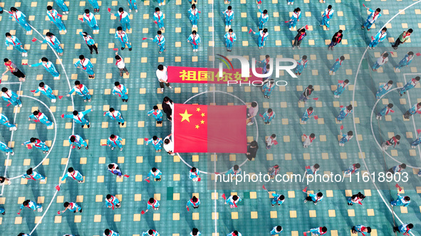 A prosecutor explains national flag knowledge to children at Qianhe Primary School in Situi Town, Guanyun County, Lianyungang City, Jiangsu...