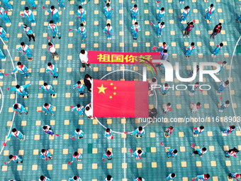 A prosecutor explains national flag knowledge to children at Qianhe Primary School in Situi Town, Guanyun County, Lianyungang City, Jiangsu...