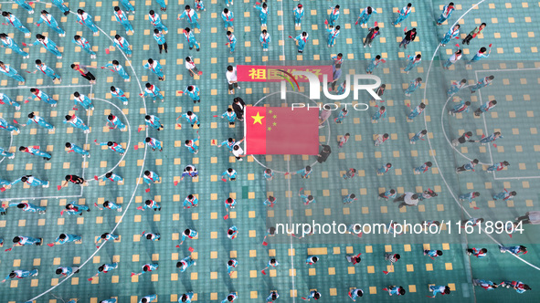 A prosecutor explains national flag knowledge to children at Qianhe Primary School in Situi Town, Guanyun County, Lianyungang City, Jiangsu...