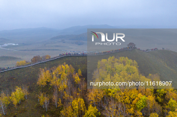 Tourists view the autumn scenery at Ulan Butong scenic spot in Chifeng, China, on September 27, 2024. 