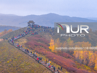 Tourists view the autumn scenery at Ulan Butong scenic spot in Chifeng, China, on September 27, 2024. (