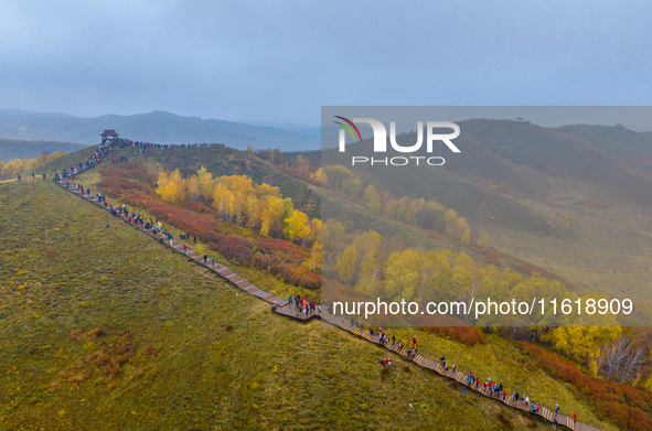 Tourists view the autumn scenery at Ulan Butong scenic spot in Chifeng, China, on September 27, 2024. 