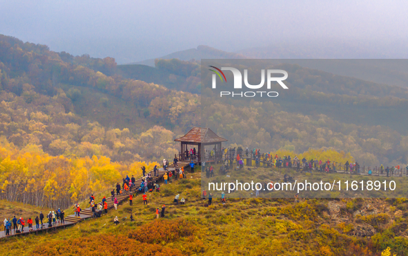 Tourists view the autumn scenery at Ulan Butong scenic spot in Chifeng, China, on September 27, 2024. 