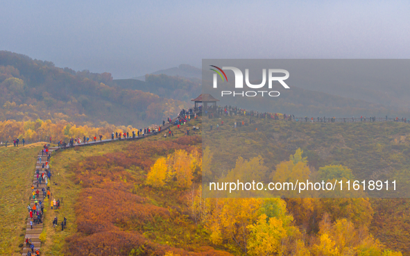 Tourists view the autumn scenery at Ulan Butong scenic spot in Chifeng, China, on September 27, 2024. 