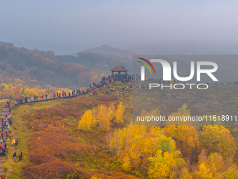 Tourists view the autumn scenery at Ulan Butong scenic spot in Chifeng, China, on September 27, 2024. (