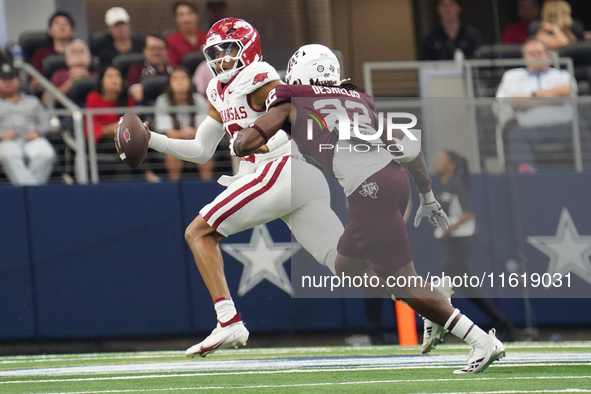 Arkansas Razorbacks quarterback Taylen Green #10 looks for an open receiver to throw the ball to while under pressure by Texas A&M linebacke...