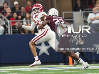 Arkansas Razorbacks quarterback Taylen Green #10 looks for an open receiver to throw the ball to while under pressure by Texas A&M linebacke...