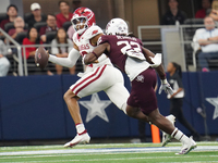 Arkansas Razorbacks quarterback Taylen Green #10 looks for an open receiver to throw the ball to while under pressure by Texas A&M linebacke...