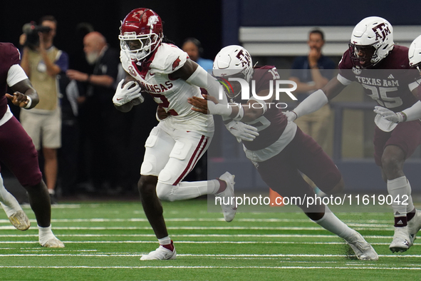 Arkansas Razorbacks wide receiver Andrew Armstrong #2 runs the ball while avoiding being tackled by Texas A&M Razorbacks defensive lineman R...