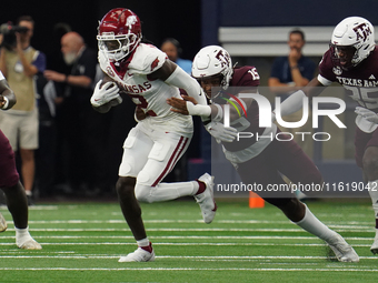 Arkansas Razorbacks wide receiver Andrew Armstrong #2 runs the ball while avoiding being tackled by Texas A&M Razorbacks defensive lineman R...