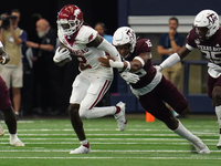 Arkansas Razorbacks wide receiver Andrew Armstrong #2 runs the ball while avoiding being tackled by Texas A&M Razorbacks defensive lineman R...