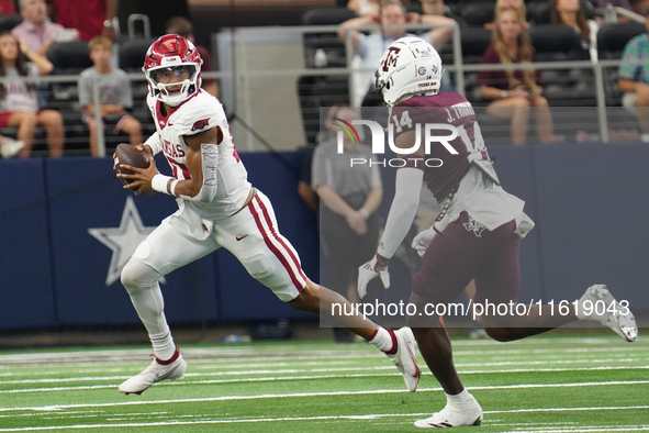 Arkansas Razorbacks quarterback Taylen Green #10 looks for an open receiver to throw the ball to while under pressure by Texas A&M defensive...