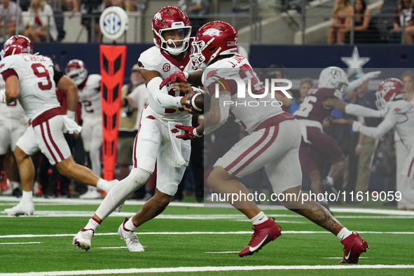 Arkansas Razorbacks quarterback Taylen Green #10 hands off to Arkansas Razorbacks running back Ja'Quinden Jackson #22 during a play against...