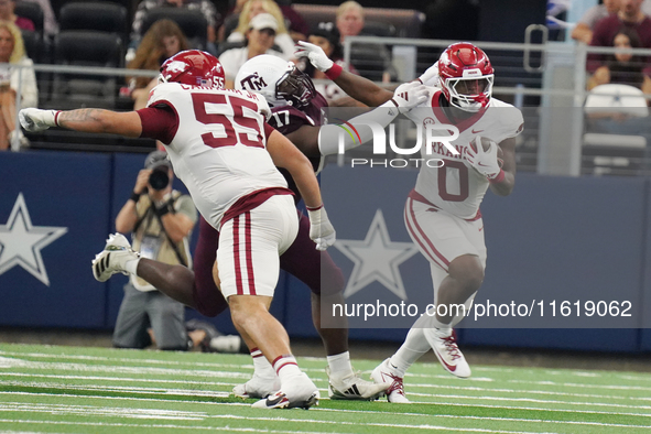 Arkansas Razorbacks running back Braylen Russell #0 runs with the ball as he eludes Texas A&M Aggies Albert Regis #17 for a yard gain during...