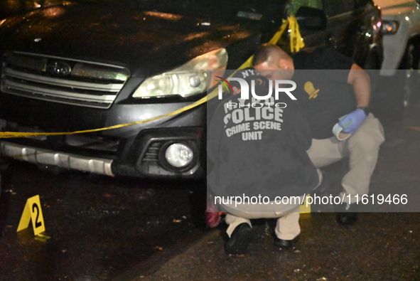 Evidence markers mark the scene where one man is killed and one man is injured in a shooting in the Kingsbridge Heights section of the Bronx...