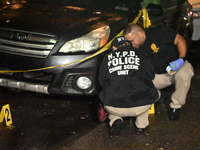 Evidence markers mark the scene where one man is killed and one man is injured in a shooting in the Kingsbridge Heights section of the Bronx...