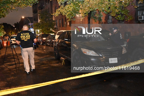 Evidence markers mark the scene where one man is killed and one man is injured in a shooting in the Kingsbridge Heights section of the Bronx...