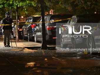 Evidence markers mark the scene where one man is killed and one man is injured in a shooting in the Kingsbridge Heights section of the Bronx...