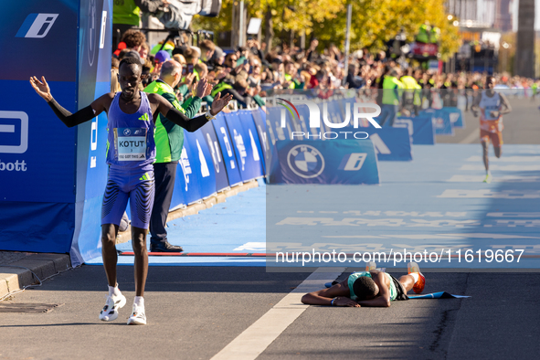 Milkesa Mengesha of Ethiopia (lying on the ground) wins the 50th Berlin Marathon with a time of 2:03:17, followed by Cybrian Kotut of Kenya...