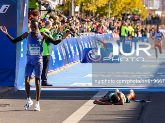 Milkesa Mengesha of Ethiopia (lying on the ground) wins the 50th Berlin Marathon with a time of 2:03:17, followed by Cybrian Kotut of Kenya...