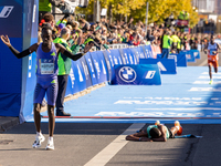 Milkesa Mengesha of Ethiopia (lying on the ground) wins the 50th Berlin Marathon with a time of 2:03:17, followed by Cybrian Kotut of Kenya...