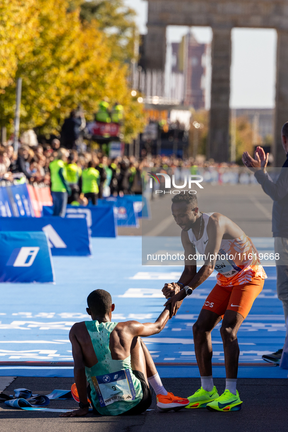 Milkesa Mengesha of Ethiopia (on the ground) wins the 50th Berlin Marathon with a time of 2:03:17, followed by Cybrian Kotut of Kenya and fe...