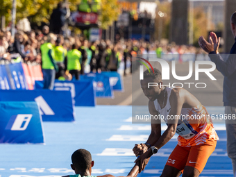 Milkesa Mengesha of Ethiopia (on the ground) wins the 50th Berlin Marathon with a time of 2:03:17, followed by Cybrian Kotut of Kenya and fe...