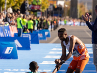 Milkesa Mengesha of Ethiopia (on the ground) wins the 50th Berlin Marathon with a time of 2:03:17, followed by Cybrian Kotut of Kenya and fe...