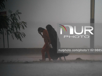 Women walk amid the heavy rains in Colombo, Sri Lanka, on September 29, 2024. (