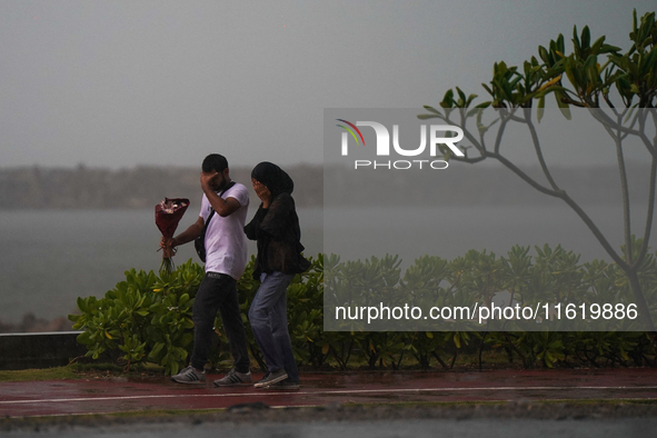 A couple walks amid the heavy rains in Colombo, Sri Lanka, on September 29, 2024. 