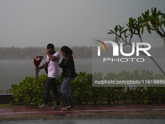 A couple walks amid the heavy rains in Colombo, Sri Lanka, on September 29, 2024. (