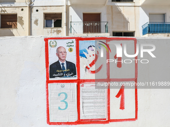 An election poster of the presidential candidate Kais Saied is pasted on a wall along a street in Ariana, Tunisia, on September 29, 2024, du...