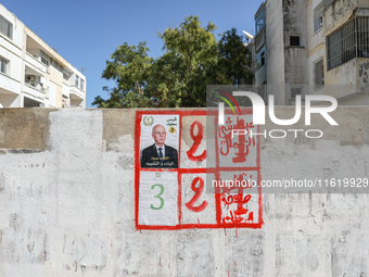 An election poster of the presidential candidate Kais Saied is pasted on a wall along a street in Ariana, Tunisia, on September 29, 2024, du...