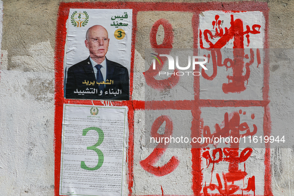 An election poster of the presidential candidate Kais Saied is pasted on a wall along a street in Ariana, Tunisia, on September 29, 2024, du...