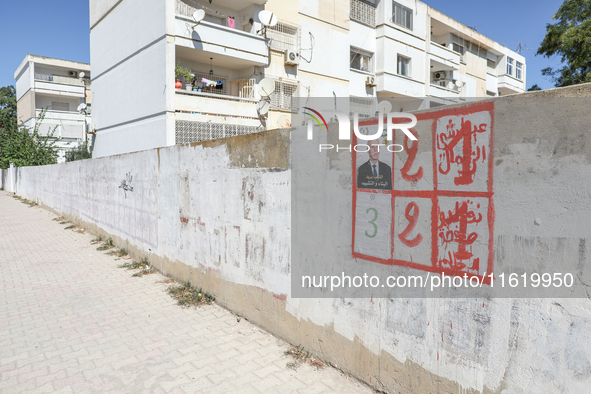 An election poster of the presidential candidate Kais Saied is pasted on a wall along a street in Ariana, Tunisia, on September 29, 2024, du...